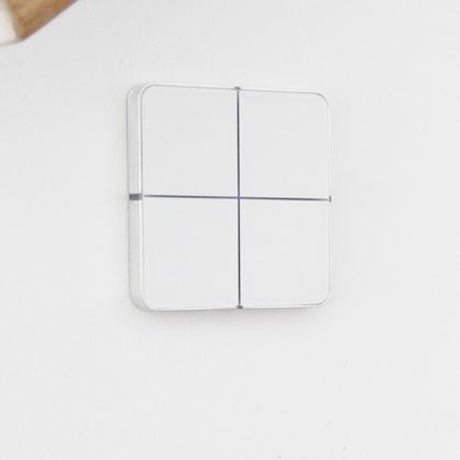 Clavier de commande à quatre touches encastré dans un mur blanc